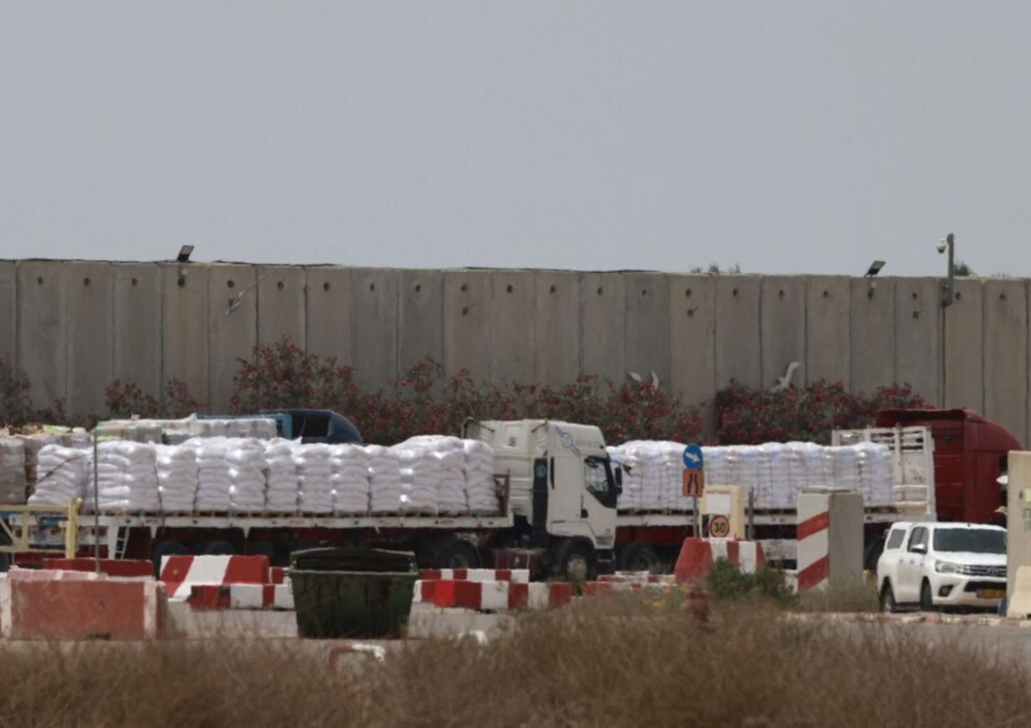 Camion che trasportano aiuti umanitari attendono sul lato israeliano del valico di frontiera di Kerem Shalom con la Striscia di Gaza, nel sud di Israele