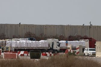 Camion che trasportano aiuti umanitari attendono sul lato israeliano del valico di frontiera di Kerem Shalom con la Striscia di Gaza, nel sud di Israele