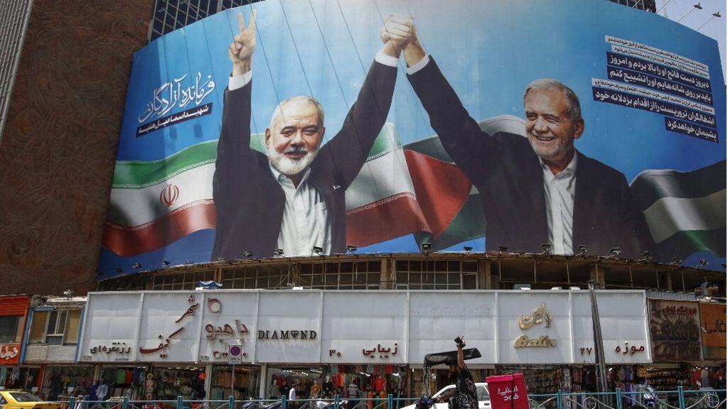 cartellone raffigurante il presidente iraniano Masoud Pezeshkian (R) e il leader del gruppo palestinese di Hamas Ismail Haniyeh, ucciso, nella piazza Valiasr di Teheran l'8 agosto 2024