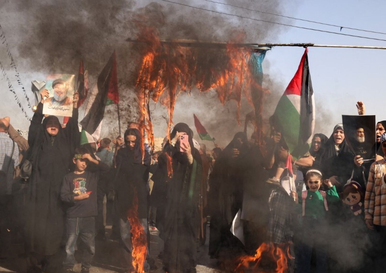 Manifestanti iraniani bruciano una bandiera israeliana a Teheran