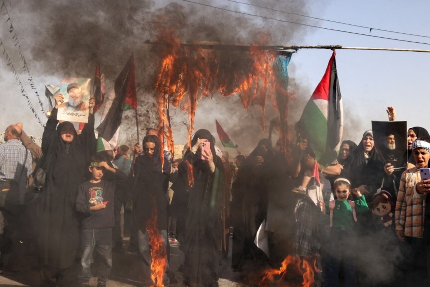 Manifestanti iraniani bruciano una bandiera israeliana a Teheran