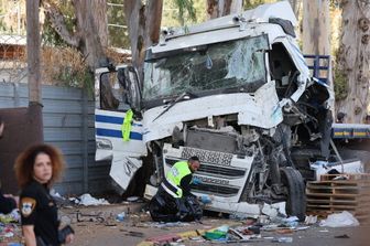 I soccorritori israeliani puliscono il sito dopo che un autista ha speronato il suo camion contro una folla di persone a una fermata dell'autobus a, a nord di Tel Aviv