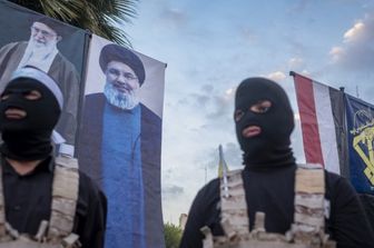 Guardie Rivoluzionarie iraniane sotto i ritratti della Guida Suprema Khamenei e leader di Hezbollah, Nasrallah