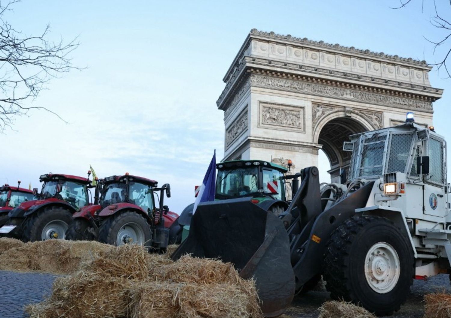 Trattori e balle di fieno sotto l’Arco di Trionfo a Parigi