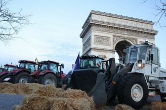 Trattori e balle di fieno sotto l’Arco di Trionfo a Parigi