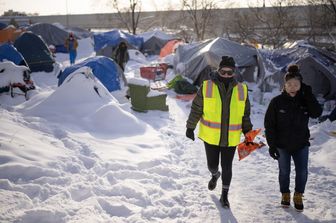 Volontari distribuiscono cibo e scaldamani in un rifugio di senzatetto a Minneapolis