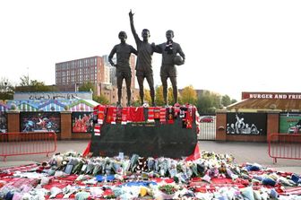 Omaggi e fiori alla base della scultura “United Trinity”, raffigurante gli ex giocatori del Manchester United George Best, Denis Law e Bobby Charlton