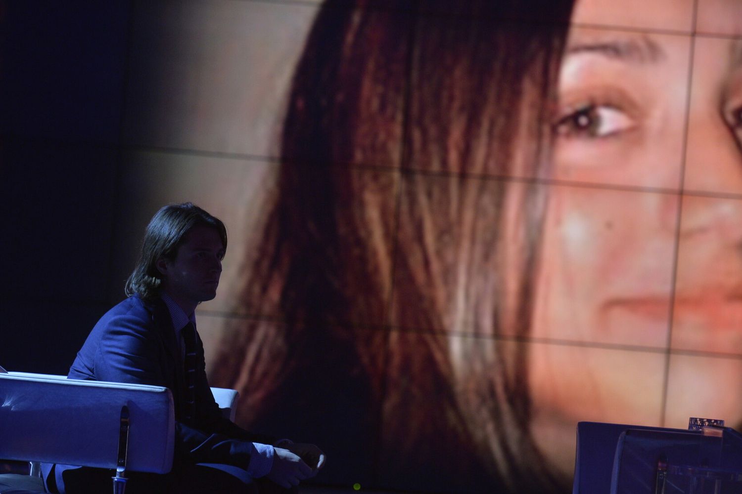 Raffaele Sollecito e sullo sfondo la foto di Meredith Kercher