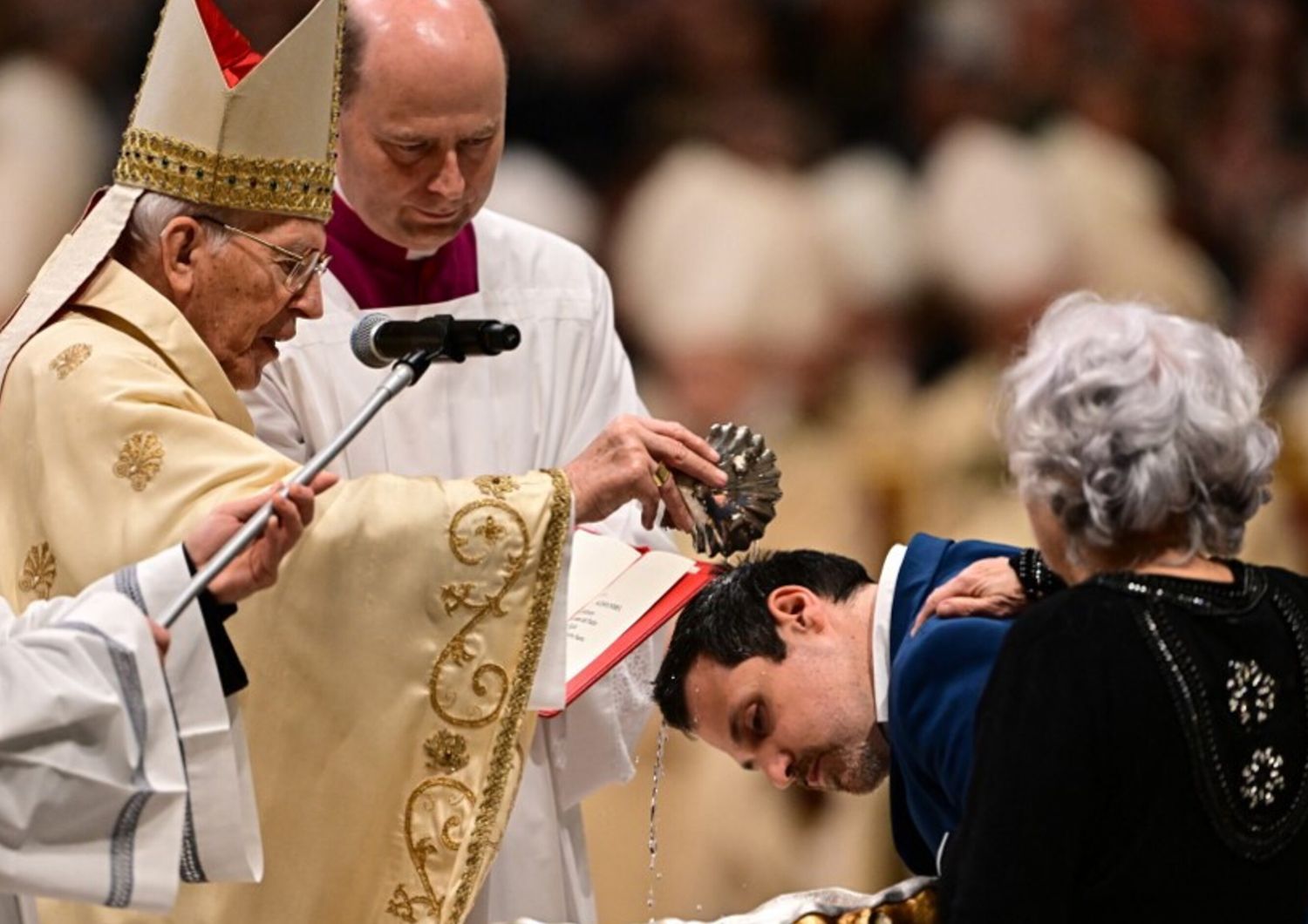 Il cardinale Giovanni Battista Re battezza un uomo durante la veglia pasquale