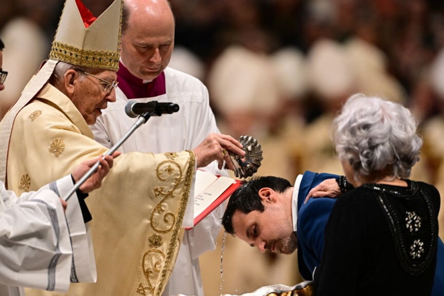 Il cardinale Giovanni Battista Re battezza un uomo durante la veglia pasquale