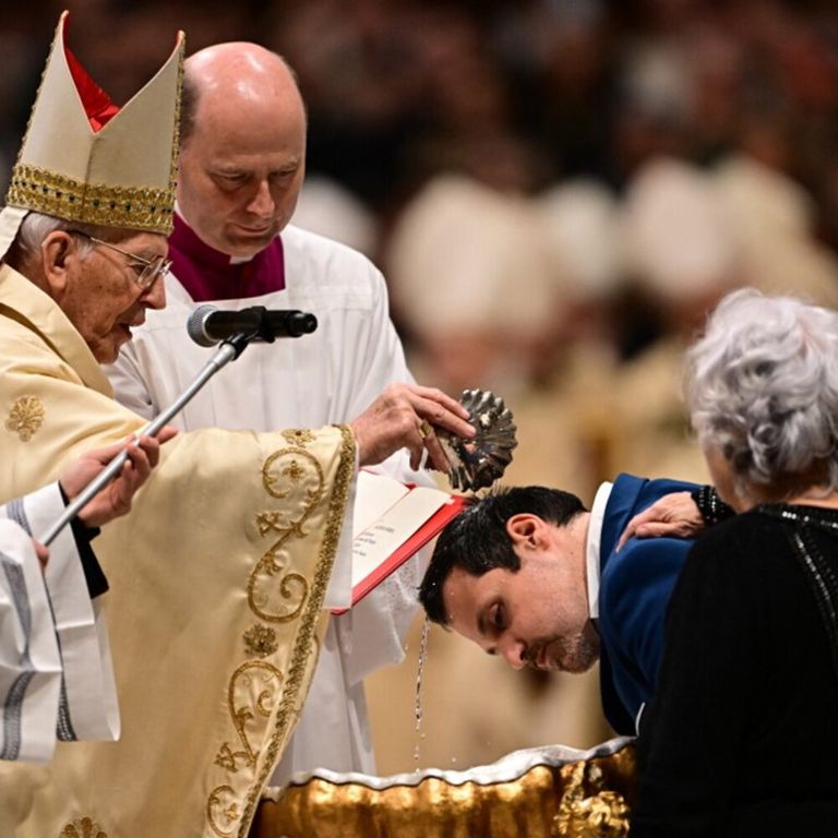 Il cardinale Giovanni Battista Re battezza un uomo durante la veglia pasquale