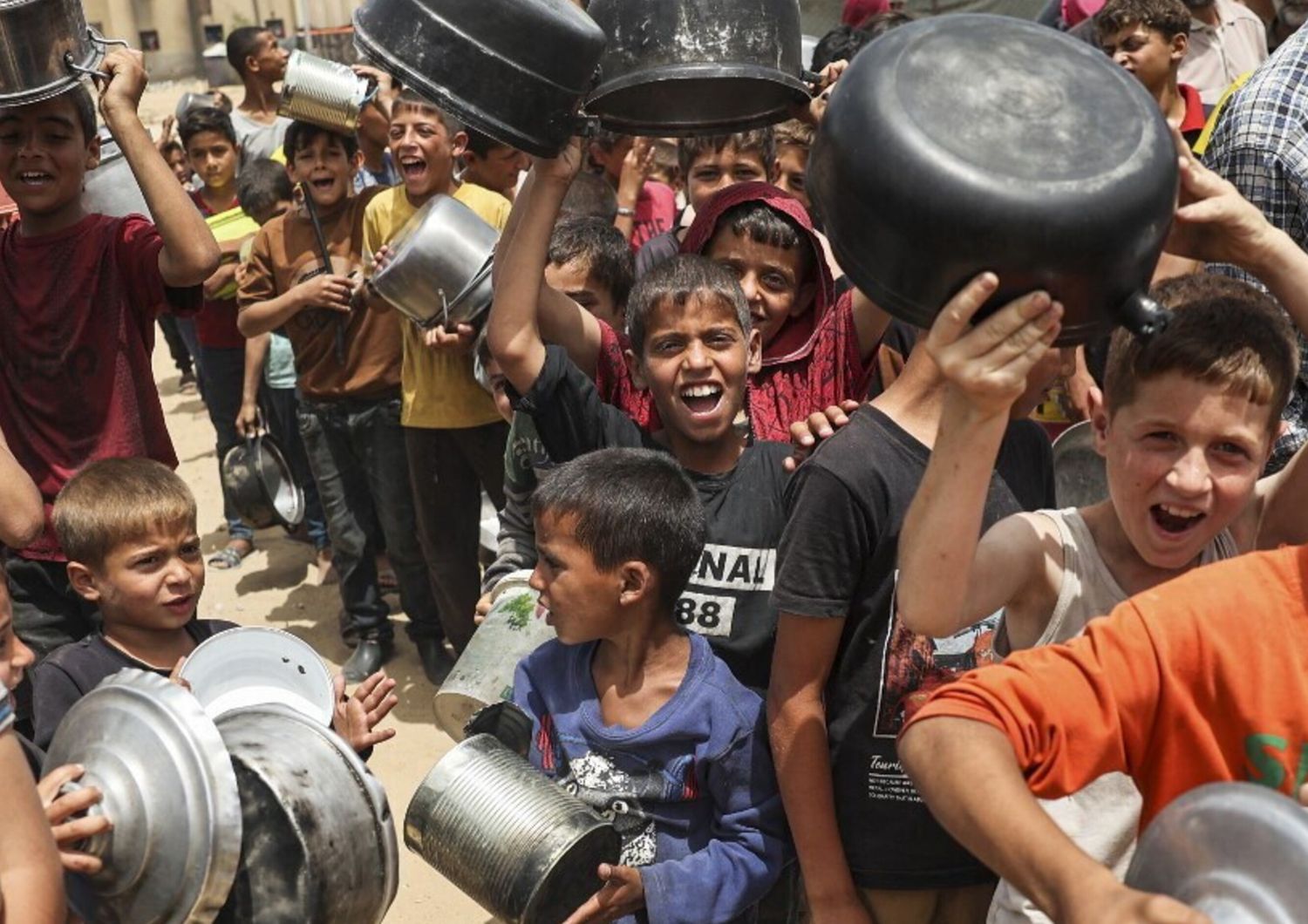 Rifugiati palestinesi in fila per ricevere aiuti arrivati tramite il valico di Rafah