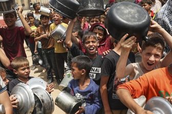 Rifugiati palestinesi in fila per ricevere aiuti arrivati tramite il valico di Rafah