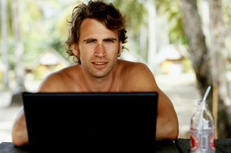 Uomo al lavoro con il suo pc mentre sta in vacanza&nbsp;