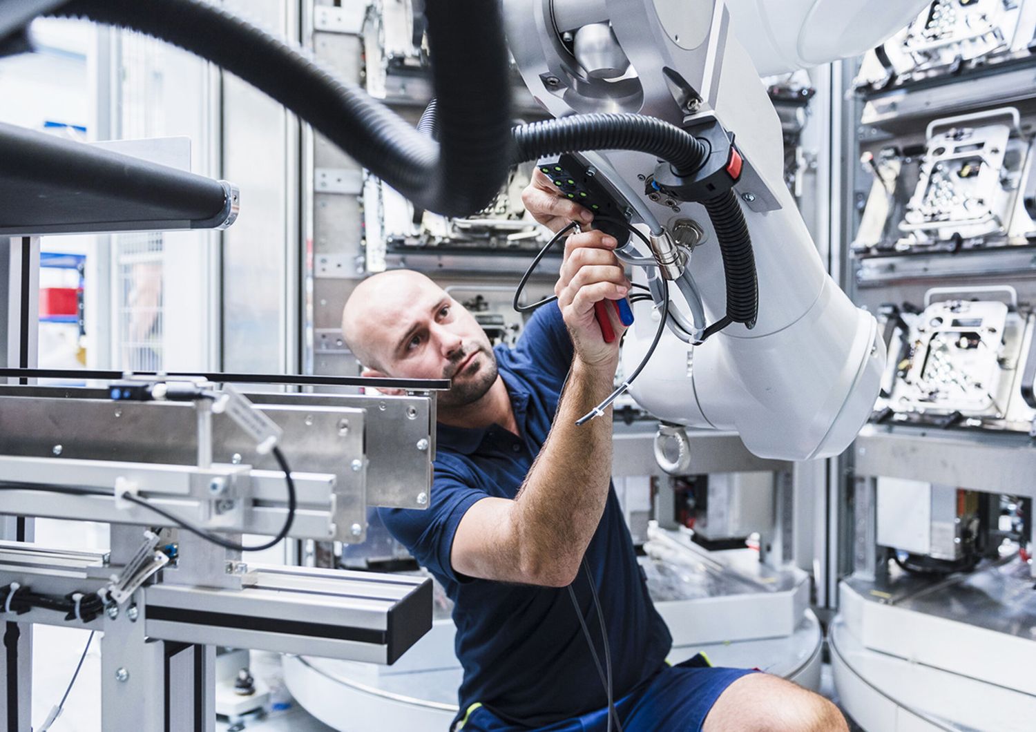 Un operaio al lavoro con un robot industriale.&nbsp;
