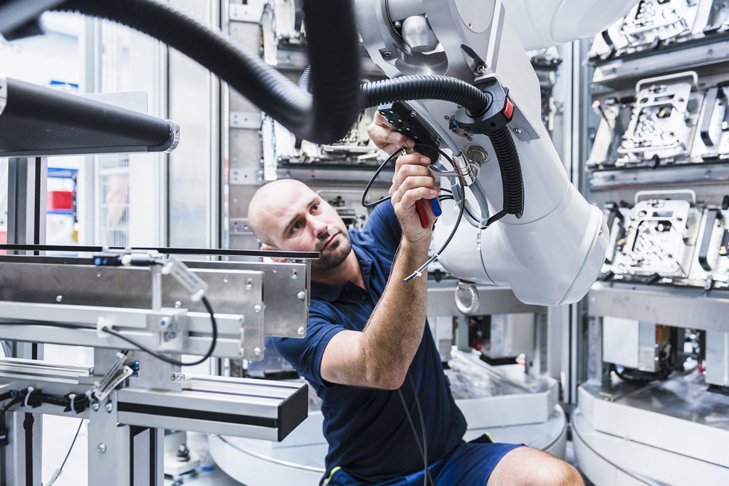 Un operaio al lavoro con un robot industriale.&nbsp;