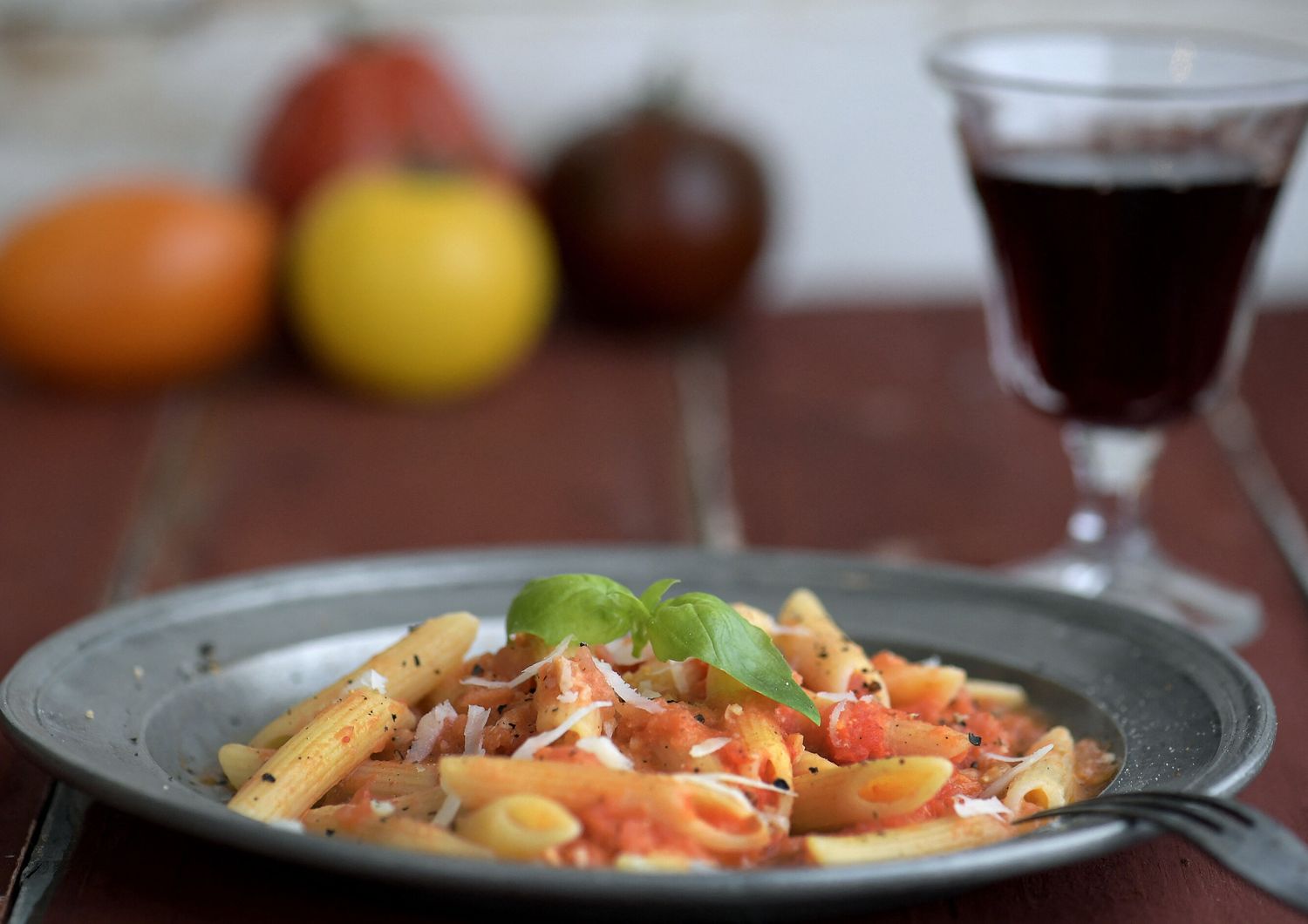 Un piatto di pasta accompagnato da un bicchiere di vino