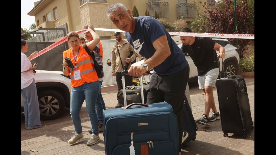 Gli israeliani lasciano le loro case in zone più sicure a seguito di un attacco iraniano che ha colpito Ness Ziona, nel centro di Israele, il 22 giugno 2025. Almeno 16 persone sono rimaste ferite e almeno un impatto è stato segnalato nel centro di Israele dopo che l'Iran ha lanciato due ondate di missili il 22 giugno contro il paese in seguito al bombardamento statunitense dei suoi siti nucleari, hanno detto i servizi di soccorso e i rapporti