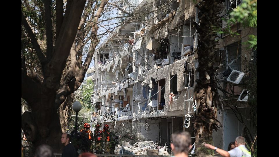 Le forze di sicurezza israeliane e i primi soccorritori si riuniscono sul luogo di un attacco iraniano che ha colpito un edificio residenziale nella zona di Ramat Aviv a Tel Aviv il 22 giugno 2025