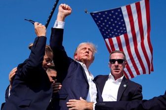 La foto iconica dell'AP dopo l'attentato di Trump insanguinato e con il pugno alzato con alle spalle la bandiera Usa