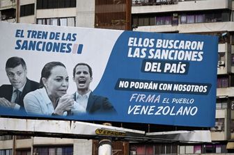 A Caracas un cartellone pubblicitario accusa i leader dell'opposizione (da sinistra a destra) Leopoldo Lopez, Maria Corina Machado e Juan Guaido, per le sanzioni statunitensi imposte al Paese