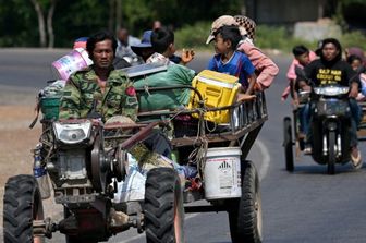 I residenti percorrono una strada con i loro veicoli dopo essere stati evacuati in seguito agli scontri al confine tra Cambogia e Thailandia