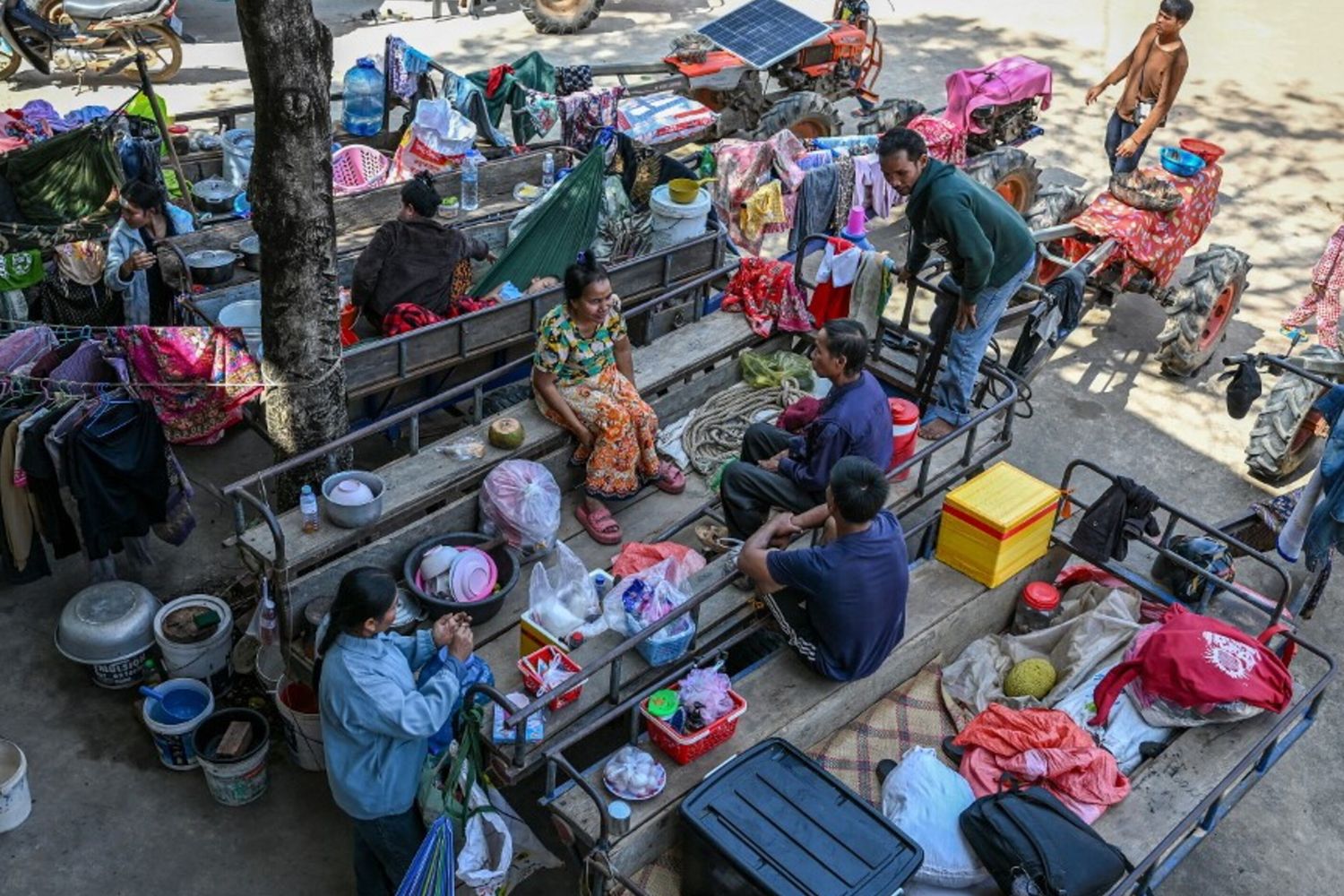 I residenti si radunano fuori da un tempio dopo essere stati evacuati in seguito agli scontri lungo il confine tra Cambogia e Thailandia