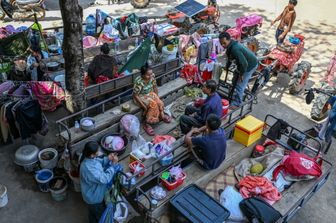 I residenti si radunano fuori da un tempio dopo essere stati evacuati in seguito agli scontri lungo il confine tra Cambogia e Thailandia
