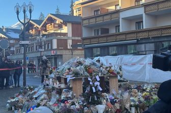 Fiori e messaggi davanti al risto-pub dove è avvenuta la tragedia a Crans-Montana