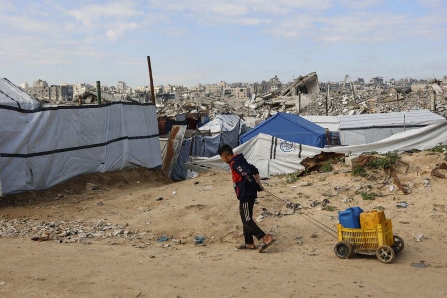 Un ragazzo sfollato vive tra le macerie delle case distrutte a Gaza dai raid dell'esercito israeliano