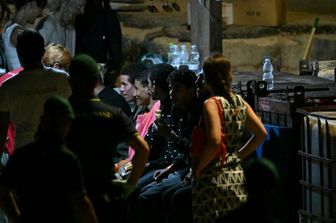 Migranti sbarcano a Lampedusa dopo essere stati salvati nell'agosto scorso