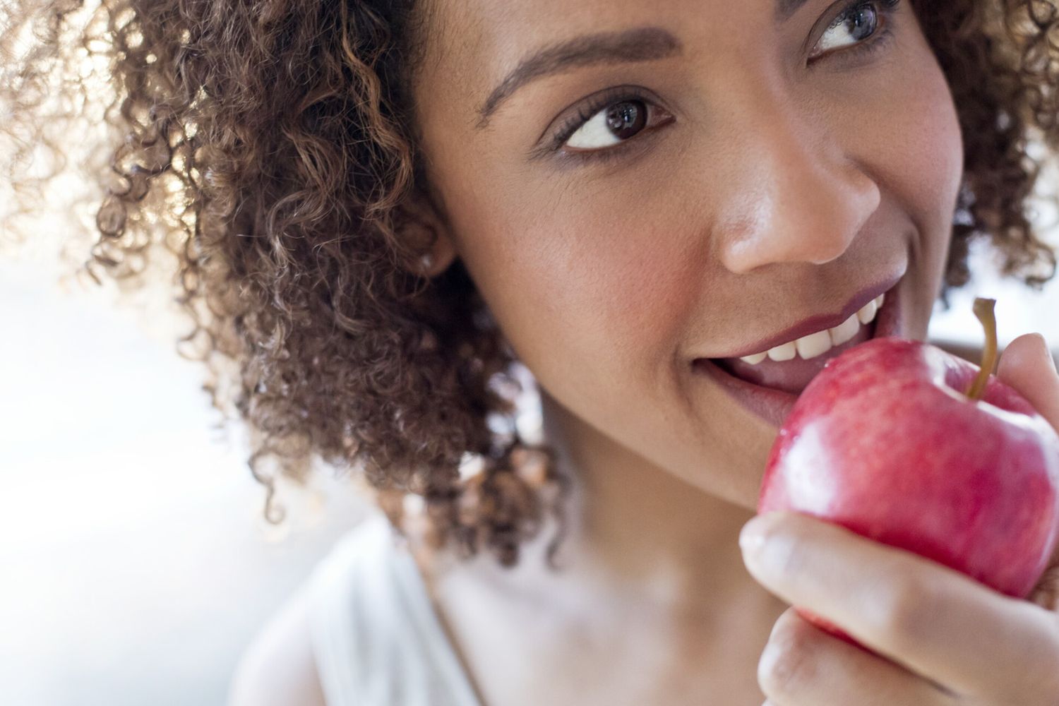 Una donna morde una mela