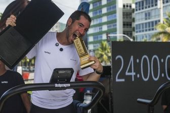 L'atleta brasiliano Pepe Fiamoncini festeggia dopo aver completato la sua sfida di correre 188 km in 24 ore su un tapis roulant, in una palestra all'aperto sulla spiaggia di Ipanema a Rio de Janeiro