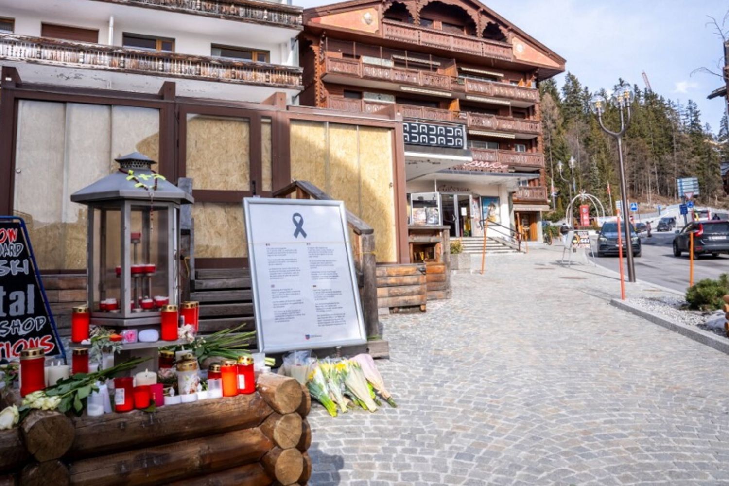 Candele e fiori esposti all'ingresso del bar "Le Constellation"