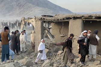 Uomini afghani cercano vittime dopo che un attacco aereo pakistano notturno ha colpito un'area residenziale nel villaggio di Girdi Kas