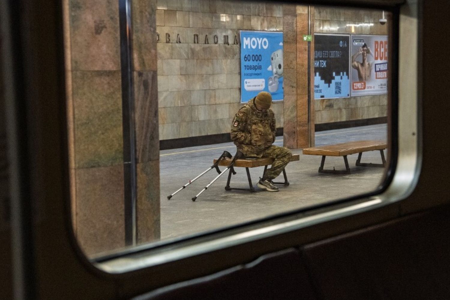 n veterano dell'esercito ucraino siede su una panchina in una stazione della metropolitana, davanti a vagoni vuoti, durante le massicce interruzioni di corrente a Kiev