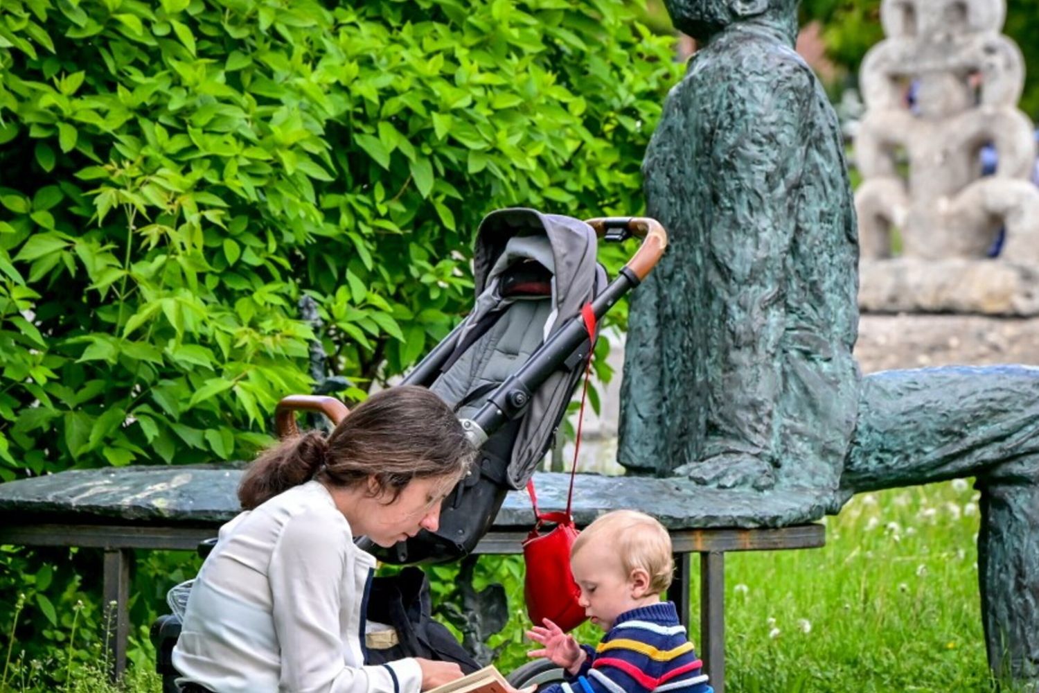 Mamma e figlio giocano nel parco centrale di Mosca vicino alla statua del premio Nobel Sakharov