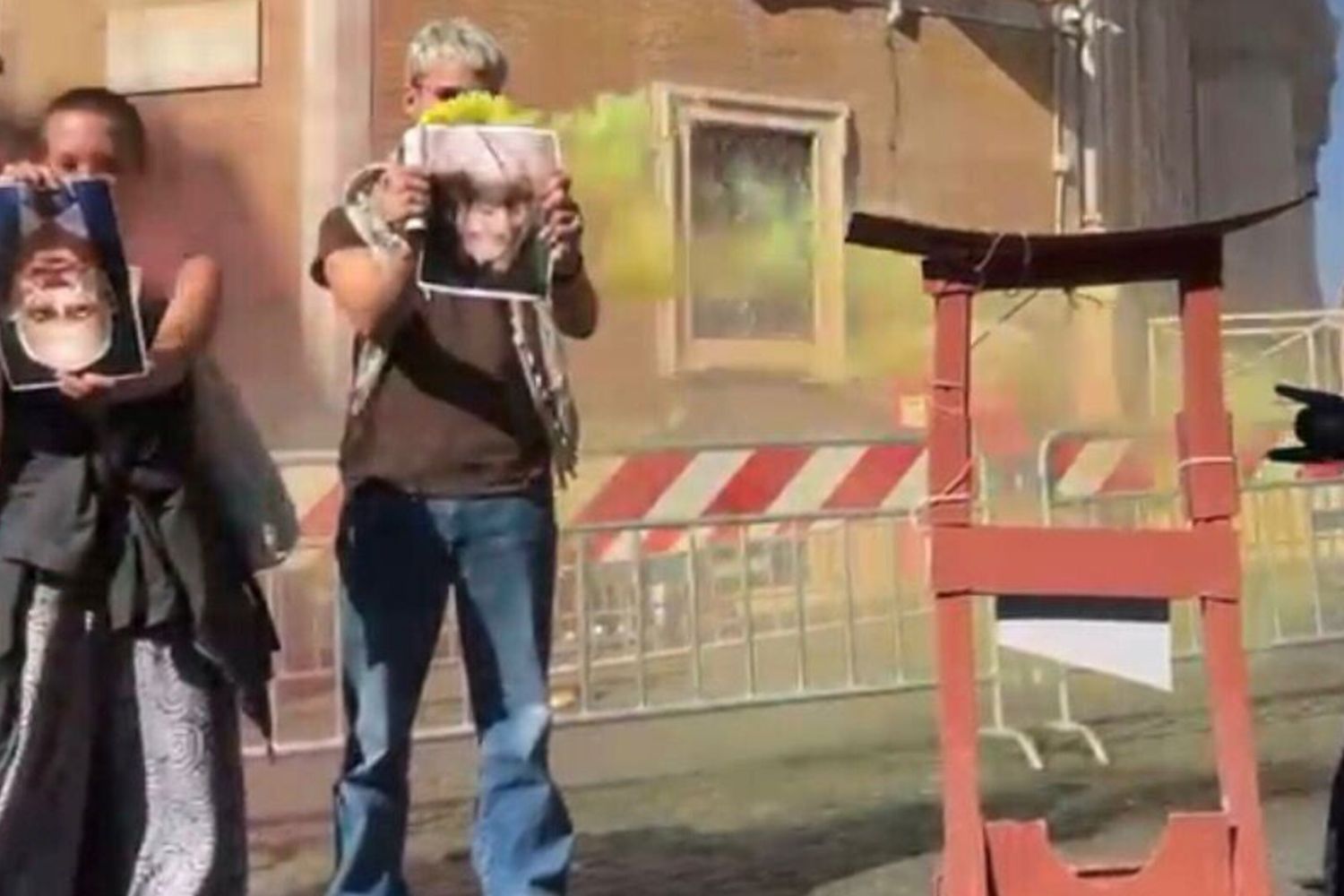 Foto di Meloni e Nordio a testa in giù accanto a una ghigliottina