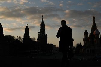 Un uomo cammina sul ponte Moskvoretsky con il Cremlino sullo sfondo