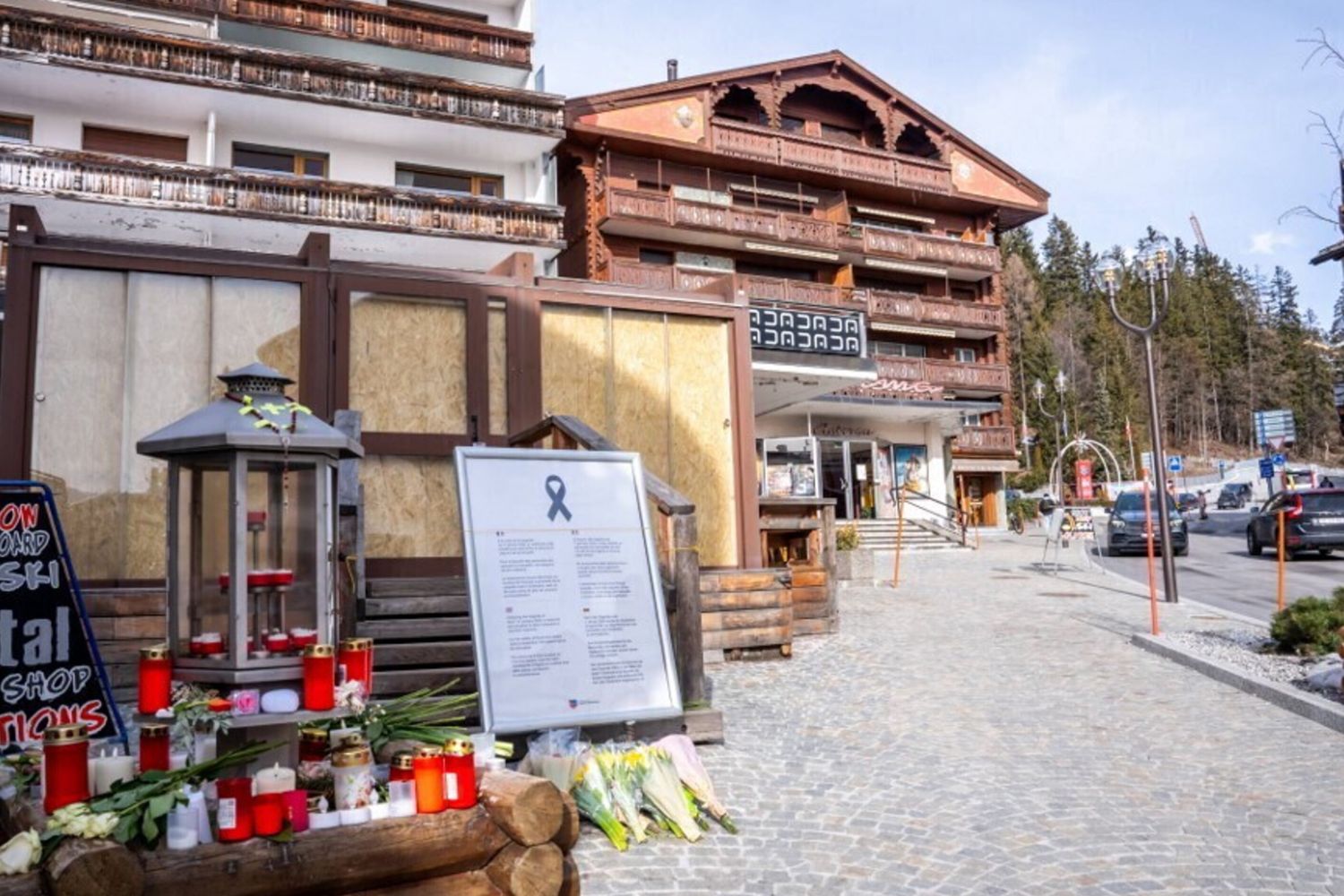 Candele e fiori esposti all'ingresso del bar "Le Constellation"