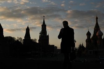 Un uomo cammina sul ponte Moskvoretsky con il Cremlino sullo sfondo