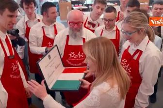 Meloni indossa il grembiule di PizzAut, durante la visita al ristorante di Monza per il Primo Maggio