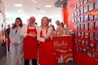 Meloni mangia la pizza da PizzAut durante la visita al ristorante a Monza per il Primo Maggio