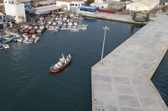 L'imbarcazione ambulanza con a bordo membri dell'equipaggio in tute protettive dopo essersi avvicinati alla nave da crociera MV Hondius, ferma al largo del porto di Praia, capitale di Capo Verde