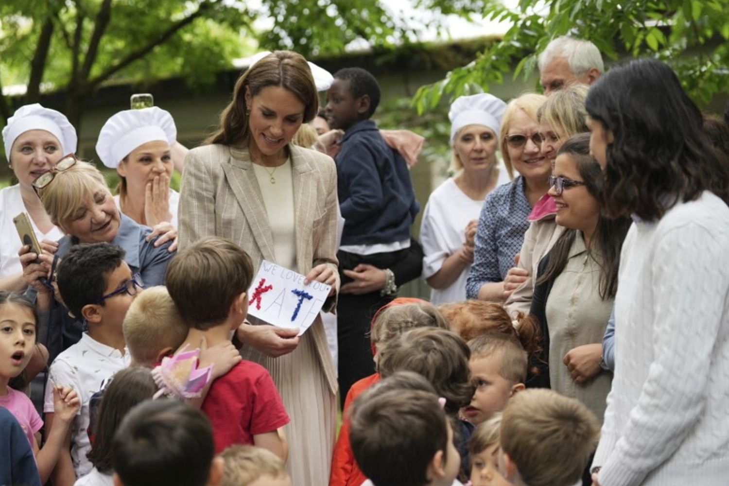 La principessa in mezzo al verde: blazer gessato e gonna plissé per l'incontro con i bambini