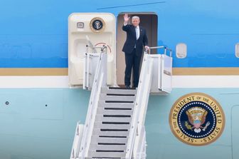 Il presidente Usa Donald Trump saluta prima del decollo da Pechino a bordo dell'Air Force One. Pochi minuti prima, lo staff ha dovuto gettare tutti i cellulari e i badge cinesi per il rischio di microspie e spionaggio