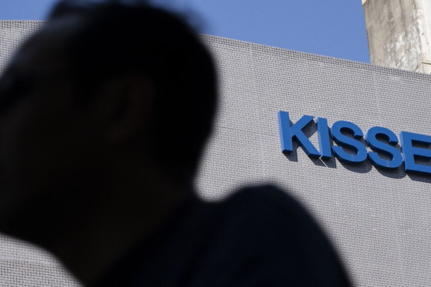 Un uomo passa davanti alla sede della Kissei Pharmaceutical a Tokyo