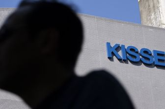 Un uomo passa davanti alla sede della Kissei Pharmaceutical a Tokyo