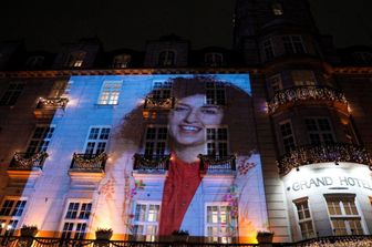 Il ritratto di Narges Mohammadi, vincitrice del Premio Nobel per la Pace 2023, viene proiettato sulla facciata del Grand Hotel nel centro di Oslo prima del banchetto di premiazione del 10 dicembre 2023