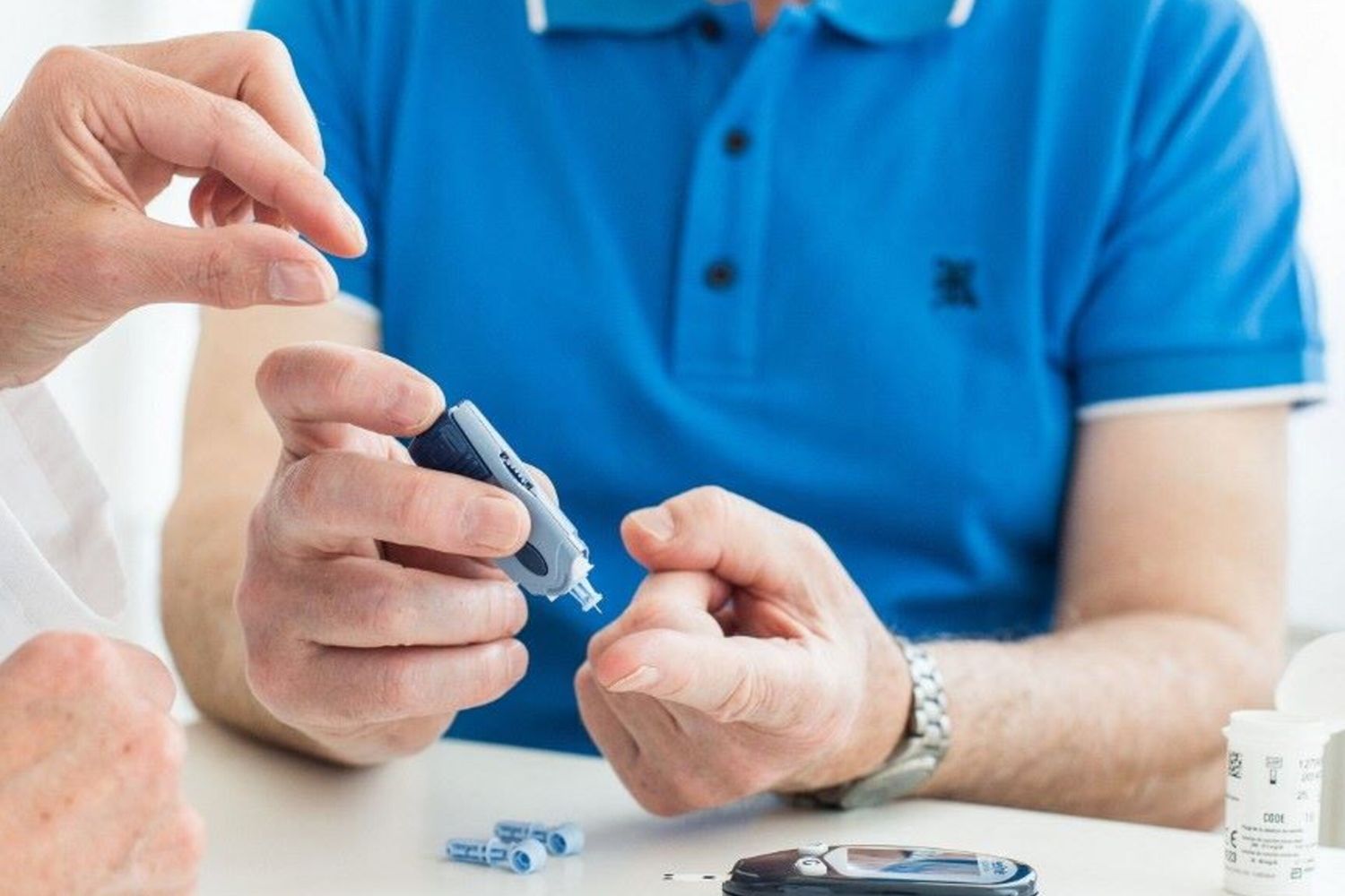 Un medico controlla la glicemia di un paziente anziano